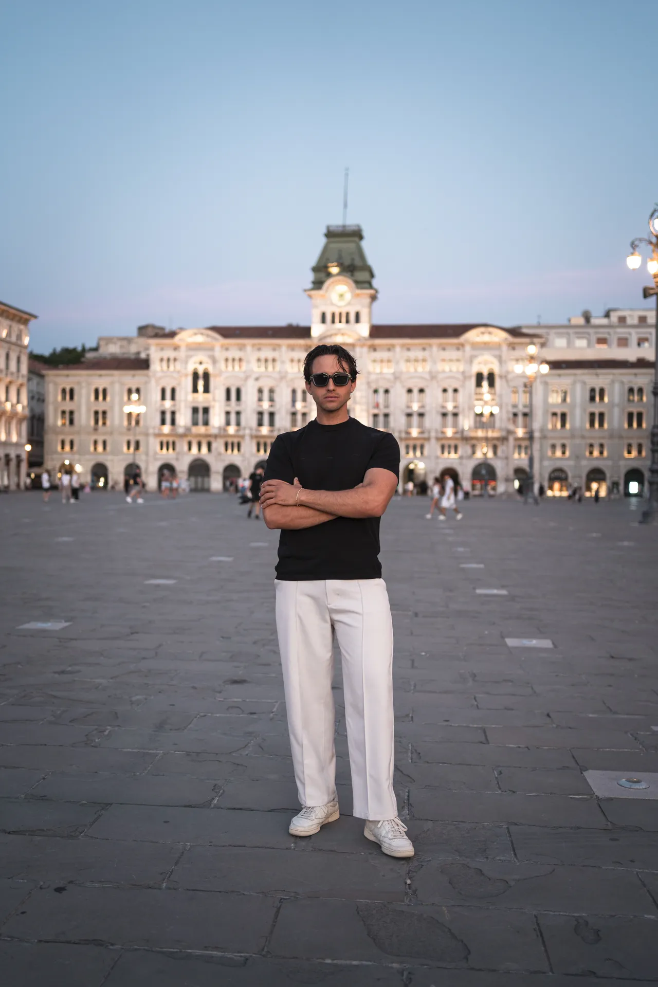 Modello con occhiali da sole Blank davanti al Municipio di Trieste al tramonto
