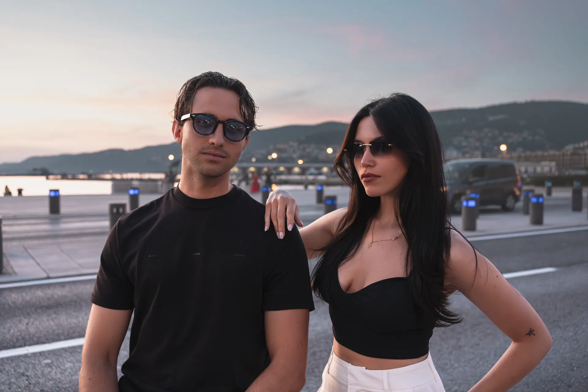 Modello e modella con occhiali da sole Blank sul lungomare di Trieste al tramonto